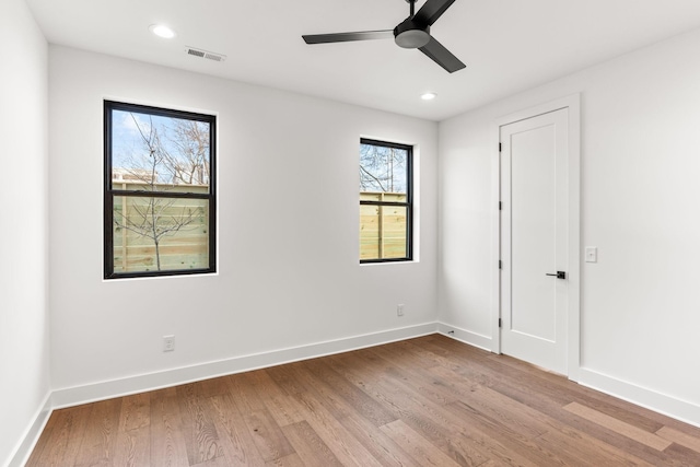 empty room with ceiling fan and light hardwood / wood-style flooring