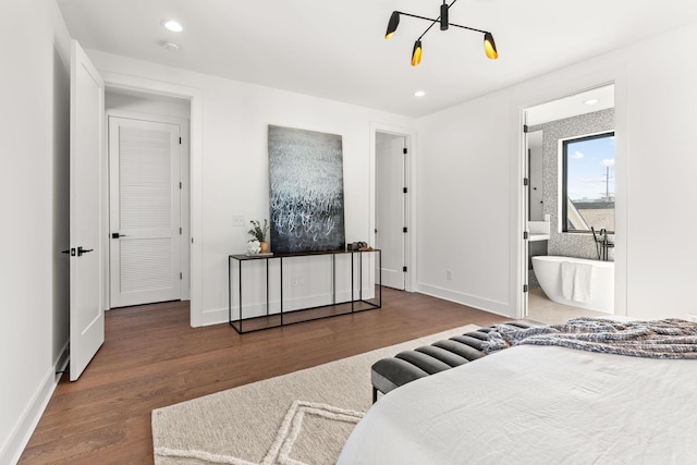 bedroom featuring ensuite bathroom and dark hardwood / wood-style floors