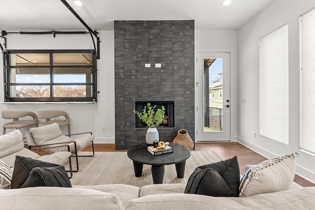 living room with wood-type flooring and a large fireplace