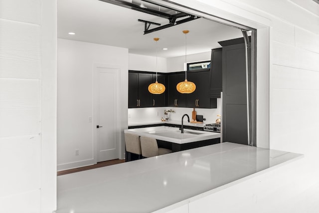 kitchen with pendant lighting, sink, and kitchen peninsula