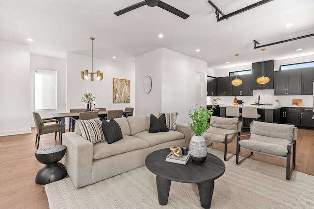 living room with sink, light hardwood / wood-style flooring, and ceiling fan