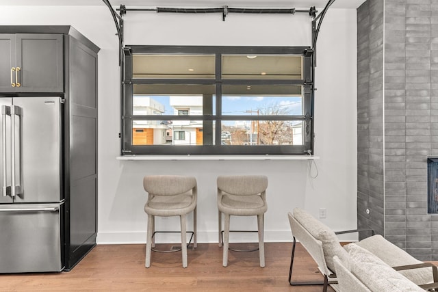 interior space with high end fridge, light hardwood / wood-style flooring, gray cabinetry, and a healthy amount of sunlight