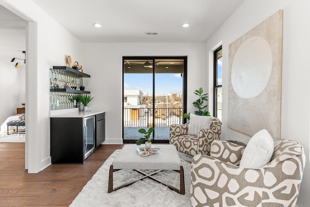 living room featuring bar and dark hardwood / wood-style flooring