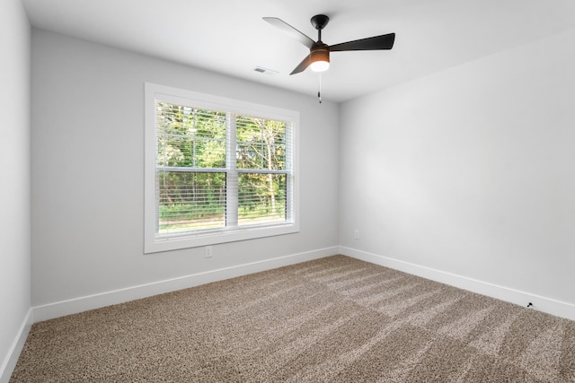 carpeted spare room with ceiling fan