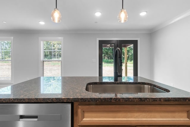 kitchen featuring dark stone counters, decorative light fixtures, and sink