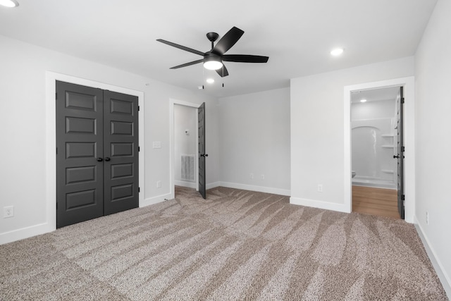 unfurnished bedroom with a closet, carpet floors, ceiling fan, and ensuite bath