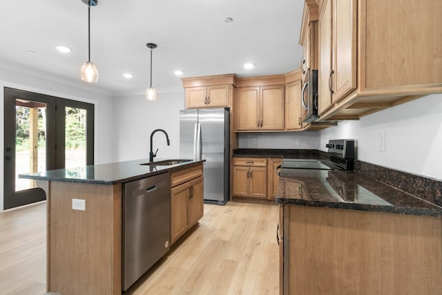 kitchen with pendant lighting, sink, crown molding, appliances with stainless steel finishes, and a center island with sink