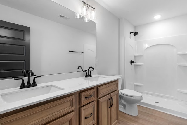 bathroom featuring vanity, hardwood / wood-style floors, toilet, and walk in shower