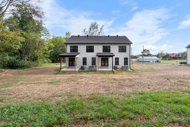 back of house featuring a lawn, a patio area, and central air condition unit