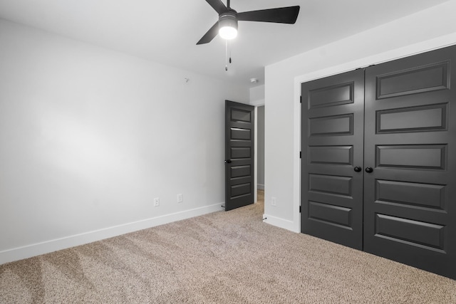 unfurnished bedroom with ceiling fan, light colored carpet, and a closet