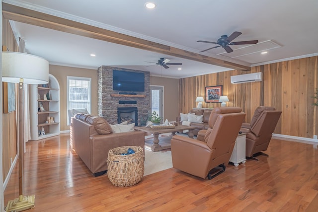 living room with ornamental molding, wooden walls, a wall unit AC, and light hardwood / wood-style flooring