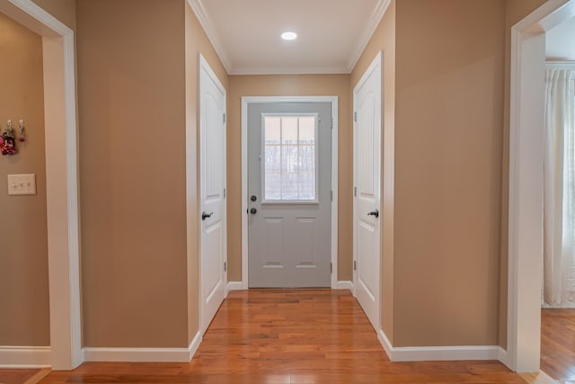 entryway featuring ornamental molding and light hardwood / wood-style floors