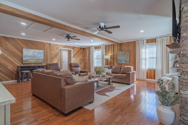 living room with hardwood / wood-style flooring, ornamental molding, beam ceiling, and a wealth of natural light