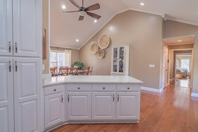 kitchen featuring vaulted ceiling and white cabinets