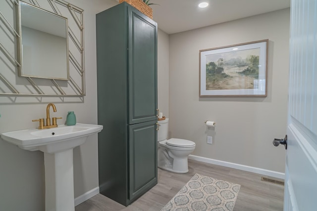 bathroom with wood-type flooring and toilet