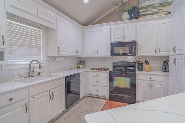 kitchen featuring sink, white cabinetry, light stone counters, vaulted ceiling, and black appliances