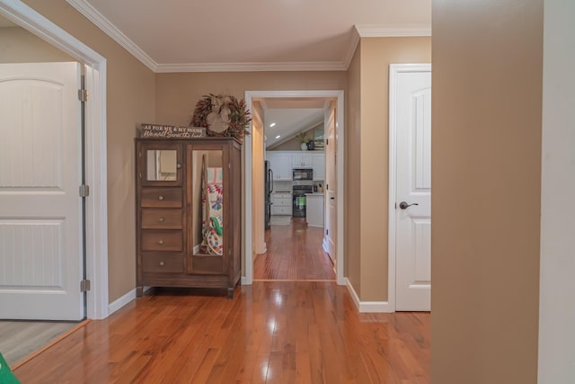 corridor featuring crown molding and light hardwood / wood-style floors