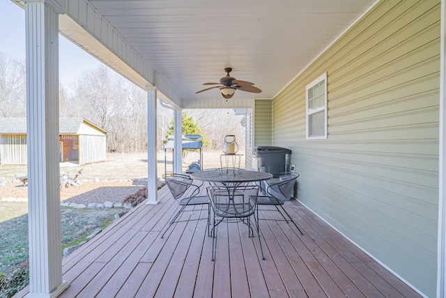 wooden deck with a shed and ceiling fan