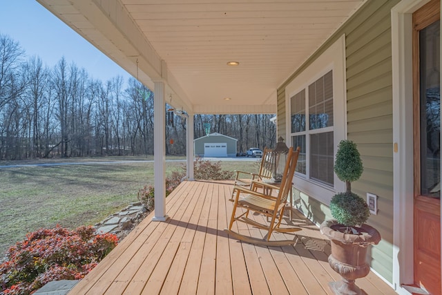 wooden deck with a porch, a garage, and a yard