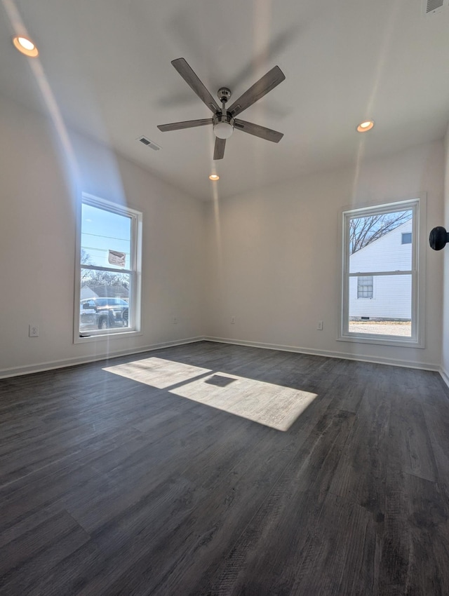 spare room with ceiling fan, a healthy amount of sunlight, and dark hardwood / wood-style flooring