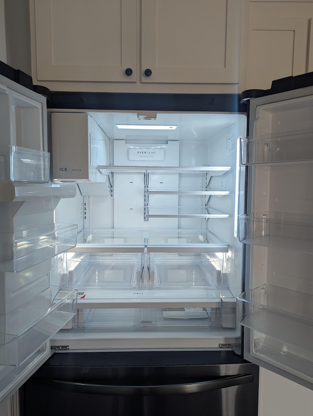 details featuring white cabinetry and fridge