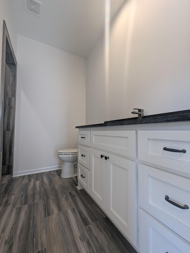 bathroom featuring vanity, toilet, and hardwood / wood-style floors