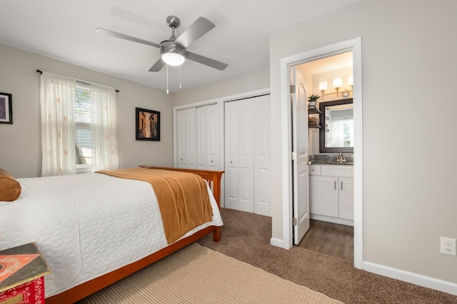 bedroom featuring a sink, multiple windows, multiple closets, and carpet floors