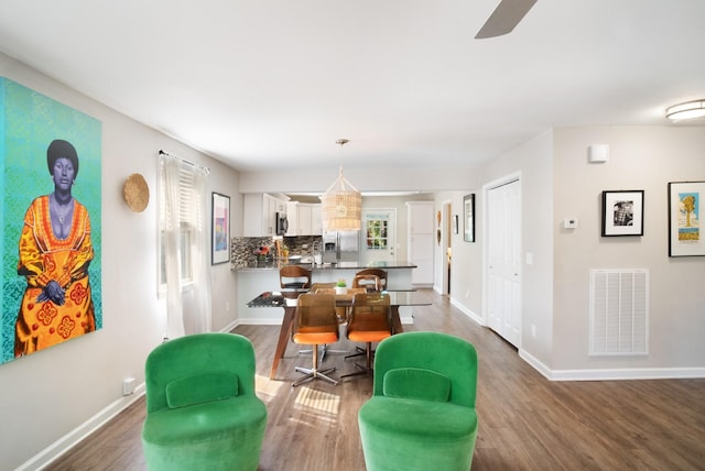 interior space featuring pendant lighting, white cabinetry, stainless steel appliances, decorative backsplash, and kitchen peninsula