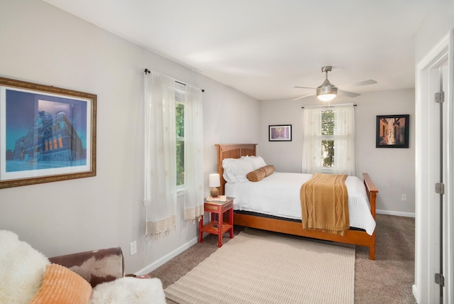 carpeted bedroom with ceiling fan and baseboards