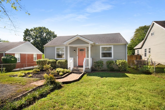 bungalow featuring roof with shingles, a front lawn, and fence