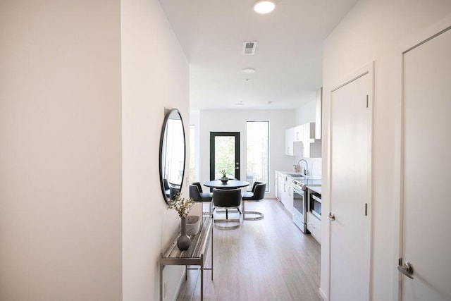 hall with sink and light hardwood / wood-style flooring