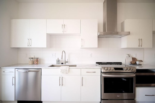 kitchen with white cabinetry, sink, stainless steel appliances, and wall chimney exhaust hood