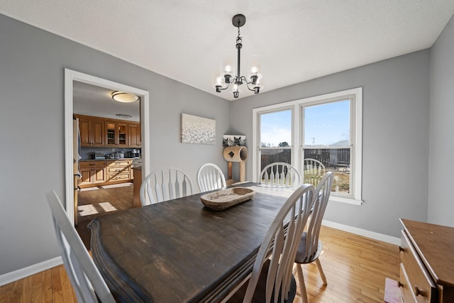 dining area featuring an inviting chandelier and light hardwood / wood-style flooring