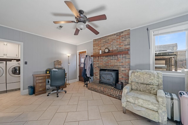 office area featuring light tile patterned floors, ornamental molding, independent washer and dryer, and a wood stove