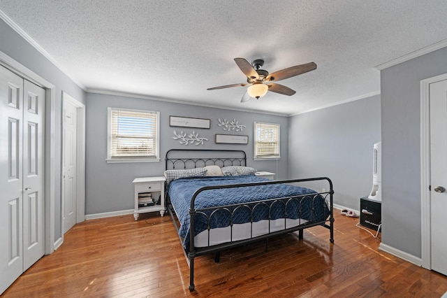 bedroom with crown molding, ceiling fan, wood-type flooring, and a textured ceiling