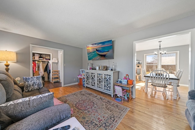 living room featuring hardwood / wood-style flooring, a chandelier, and a textured ceiling