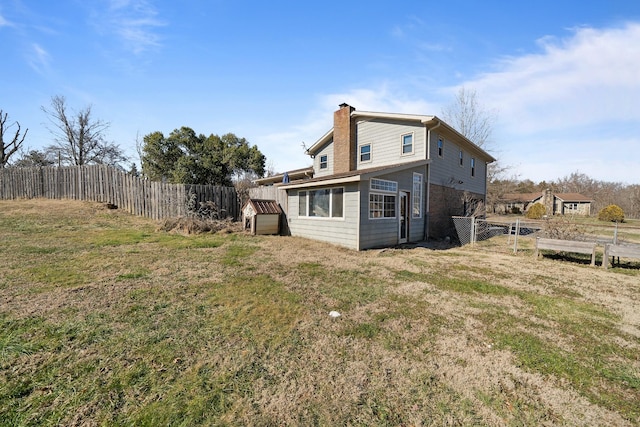 rear view of house featuring a yard