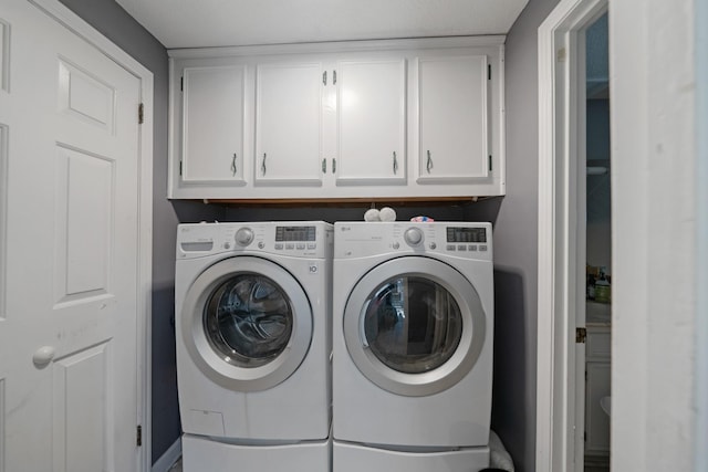 laundry area featuring cabinets and washer and clothes dryer