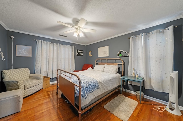 bedroom with crown molding, hardwood / wood-style flooring, a textured ceiling, and ceiling fan