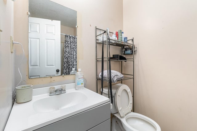 bathroom with vanity, toilet, and curtained shower