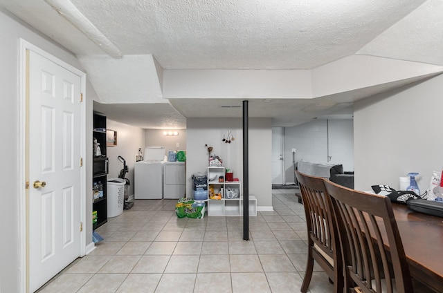 interior space featuring washing machine and clothes dryer, a textured ceiling, and light tile patterned floors