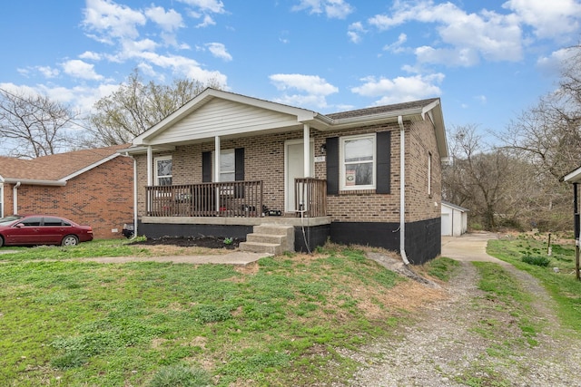 view of front of home featuring an outbuilding, a garage, a front yard, and covered porch