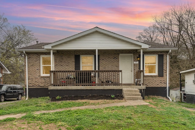 view of front of property featuring a porch and a lawn