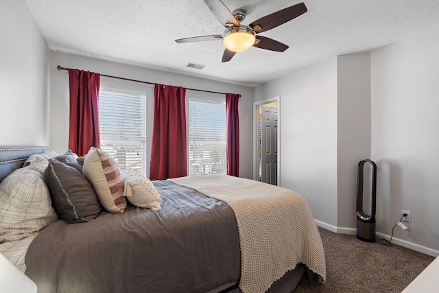 bedroom with ceiling fan, carpet flooring, and a textured ceiling