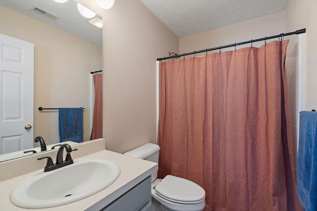 bathroom featuring vanity, toilet, and a textured ceiling