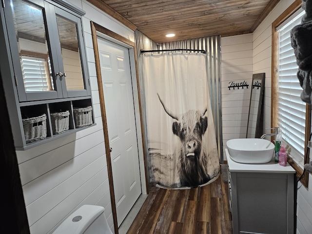 bathroom with wooden walls, hardwood / wood-style flooring, vanity, toilet, and wooden ceiling