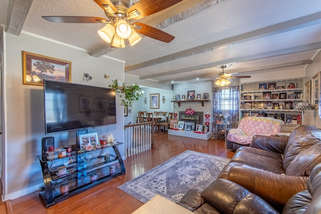 living room featuring crown molding, a textured ceiling, ceiling fan, beam ceiling, and hardwood / wood-style floors