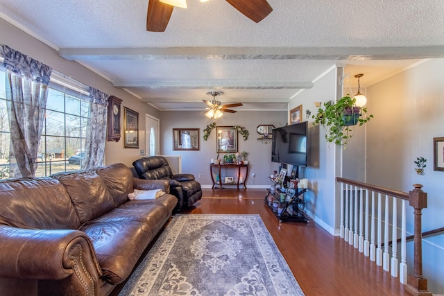 living room featuring ceiling fan, dark wood-type flooring, beamed ceiling, and a textured ceiling