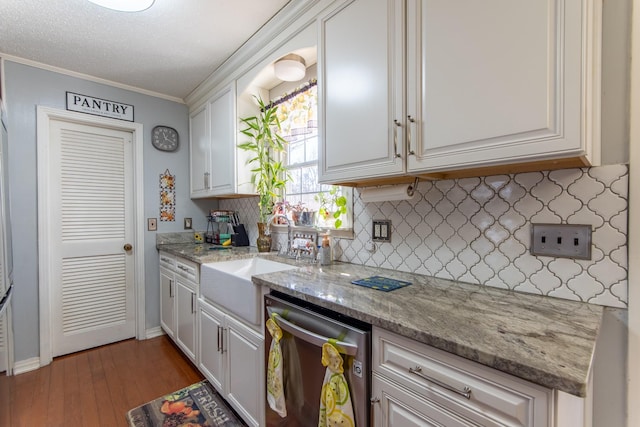 kitchen featuring dishwasher, sink, white cabinets, and light stone counters