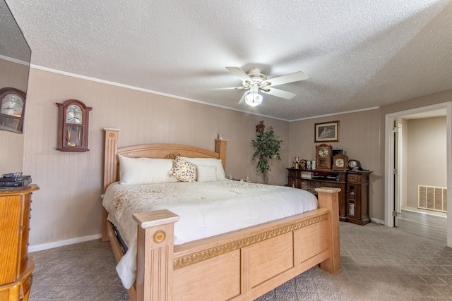 bedroom featuring crown molding, a textured ceiling, light colored carpet, and ceiling fan